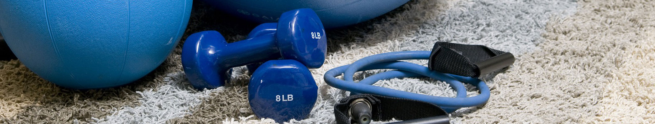 Hanteln Springseil Gymnastikbälle liegen auf dem Boden verstreut